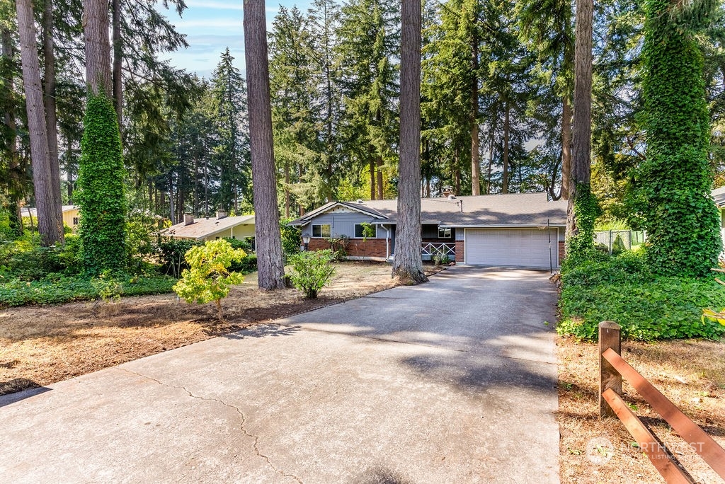 a front view of a house with garden and trees