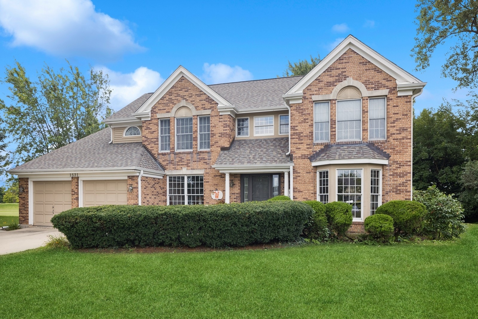 a front view of a house with a yard and garage