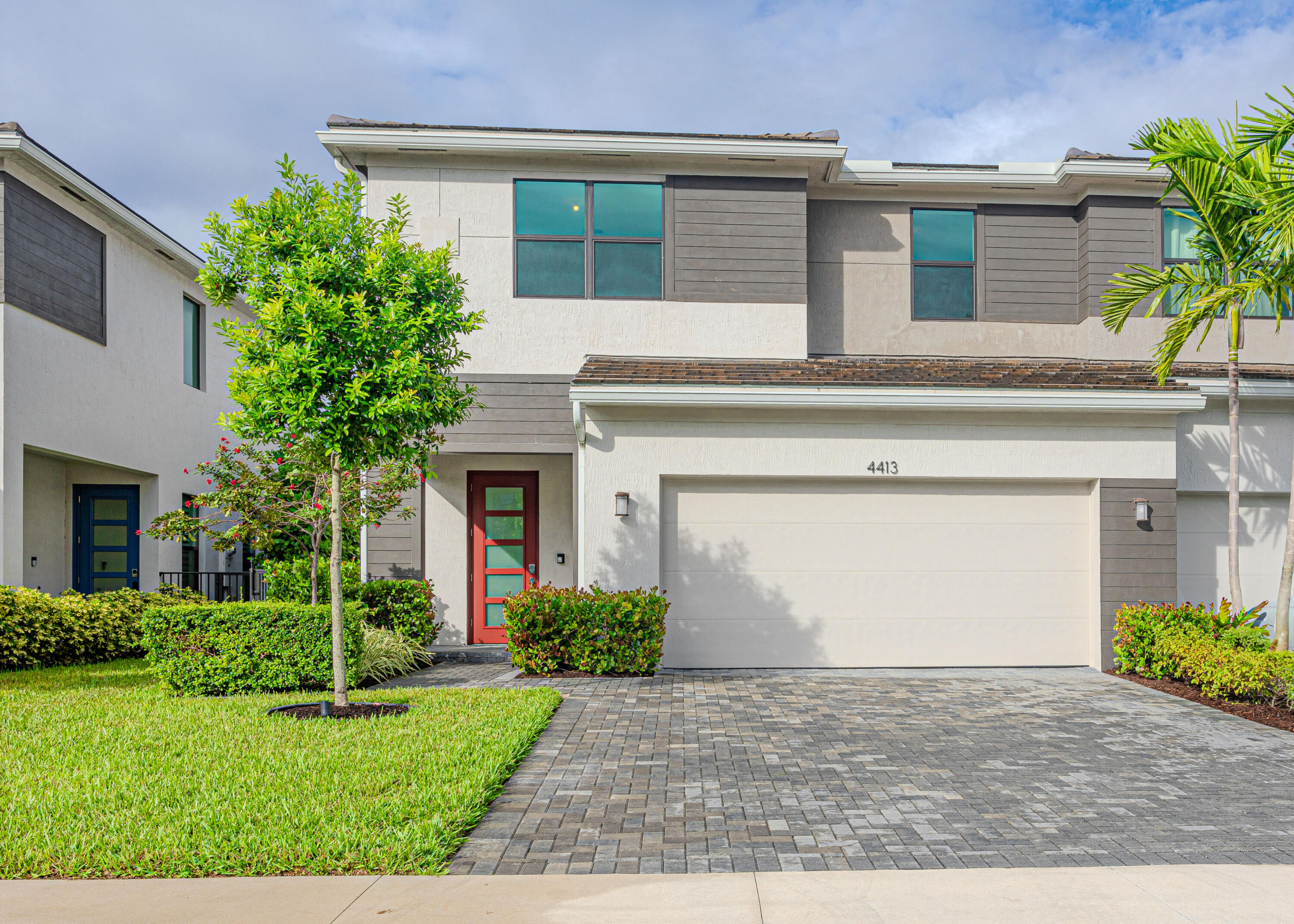 a front view of a house with a garden and garage