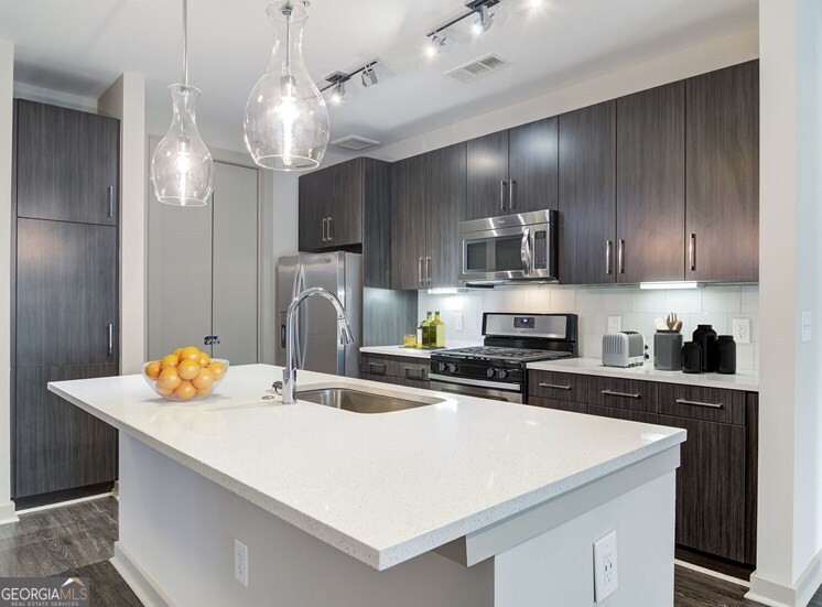 a kitchen with stainless steel appliances a sink stove and refrigerator