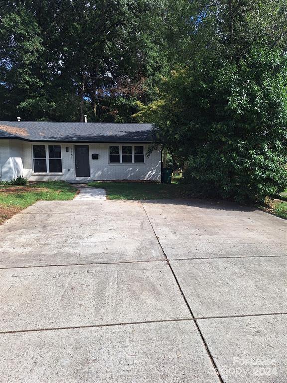 a front view of a house with a yard and trees