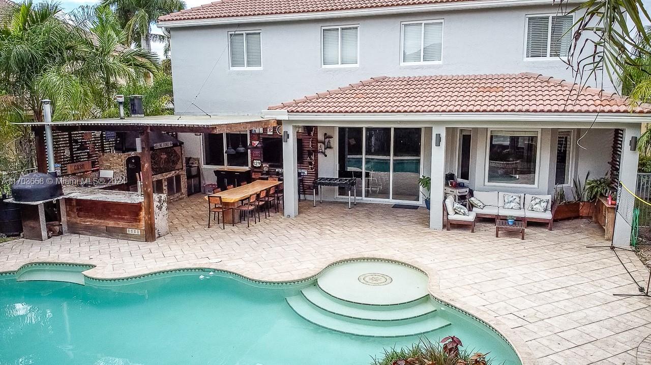 a view of a house with swimming pool and sitting area