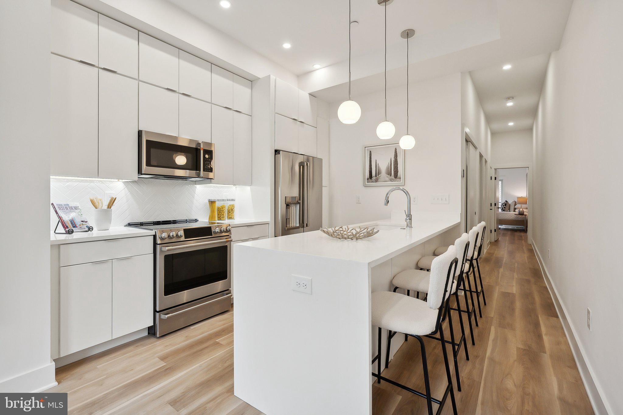 a kitchen with kitchen island a sink appliances and cabinets