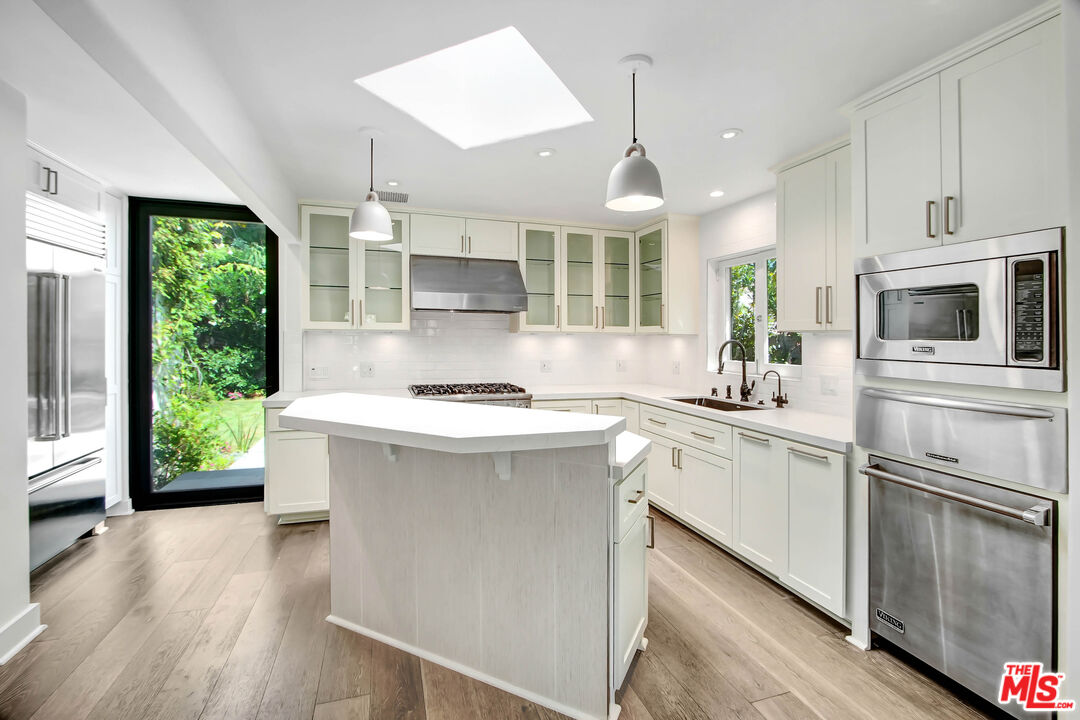 a kitchen with a sink stainless steel appliances a window and a counter top space