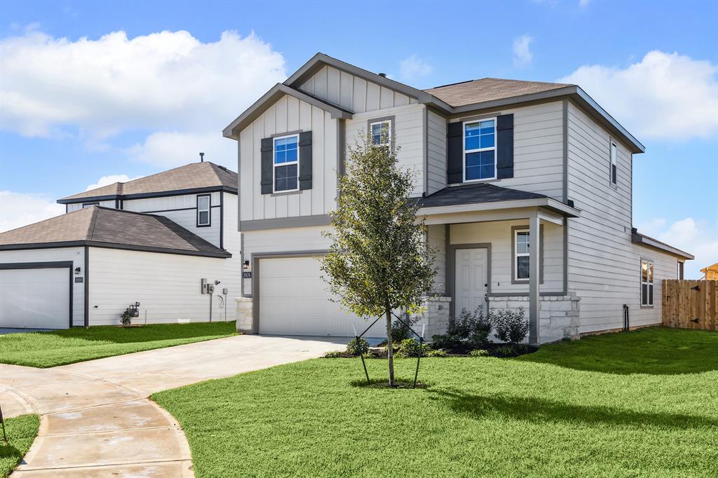 a front view of a house with a yard and trees