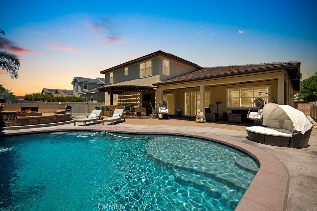 a view of a patio with couches and a table and chairs with wooden floor and fence