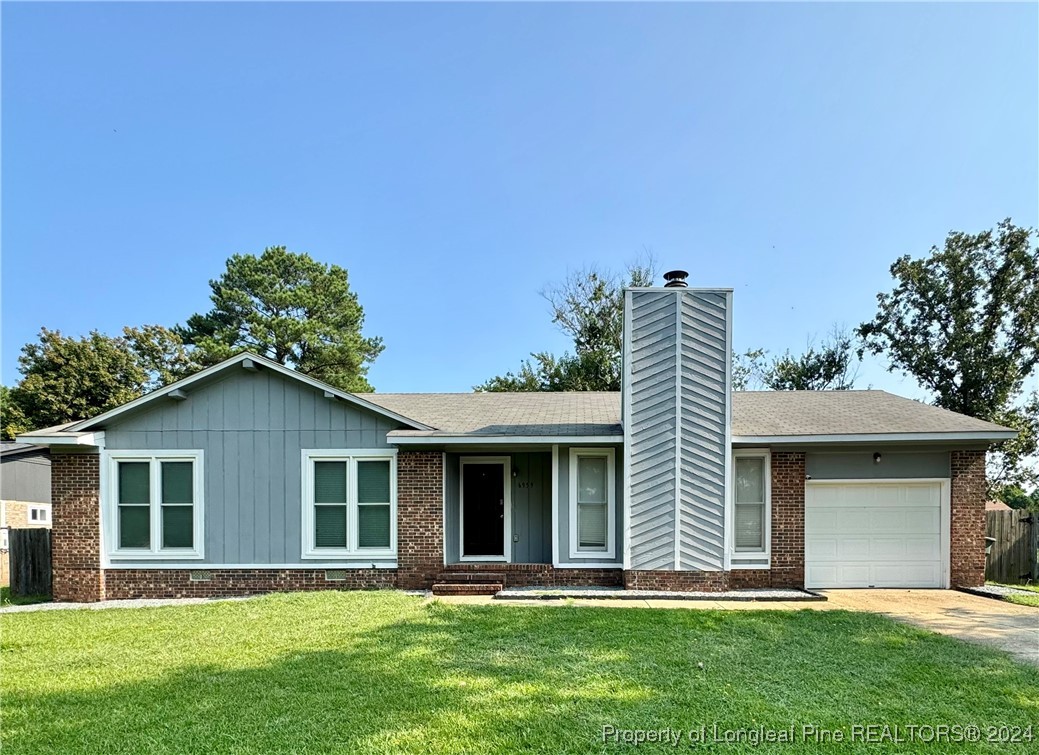 a front view of a house with a yard and trees