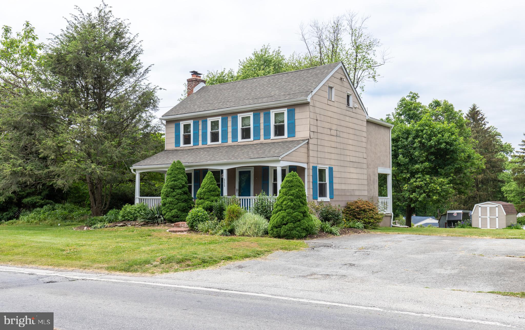 a front view of a house with a yard and potted plants