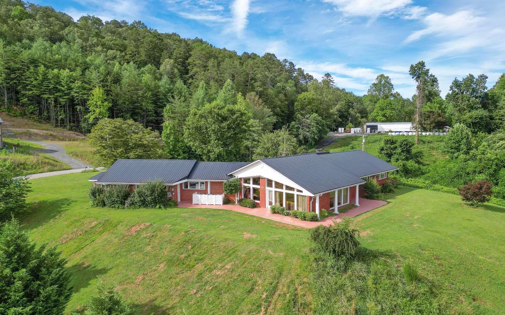 an aerial view of a house with yard and green space