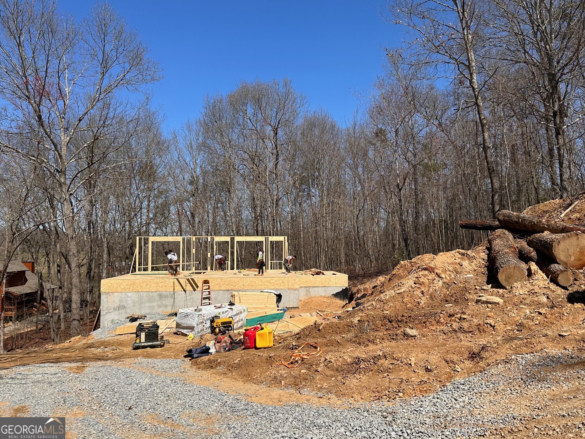 a view of backyard with a fire pit and trees