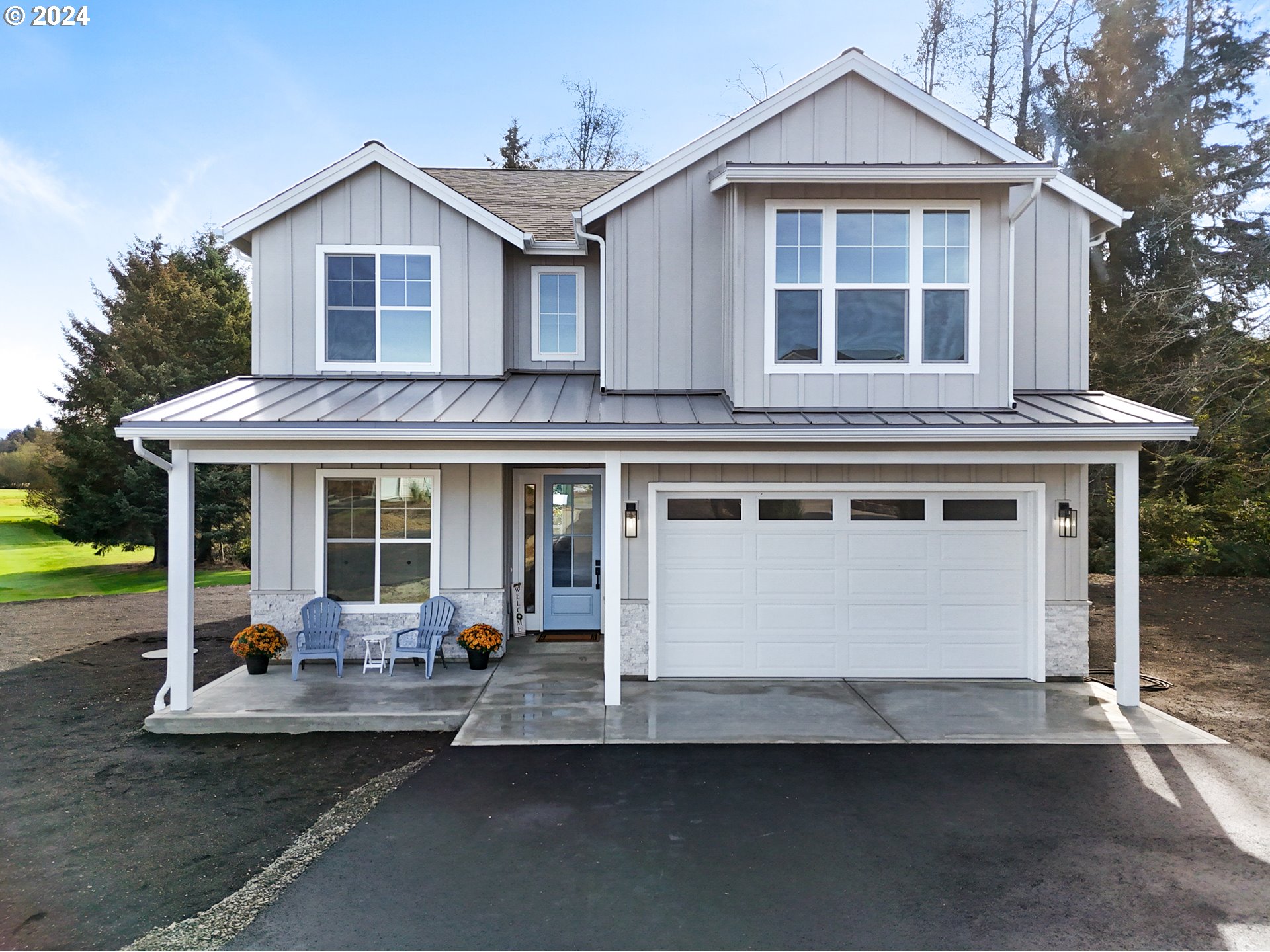 a front view of a house with a yard outdoor seating and garage