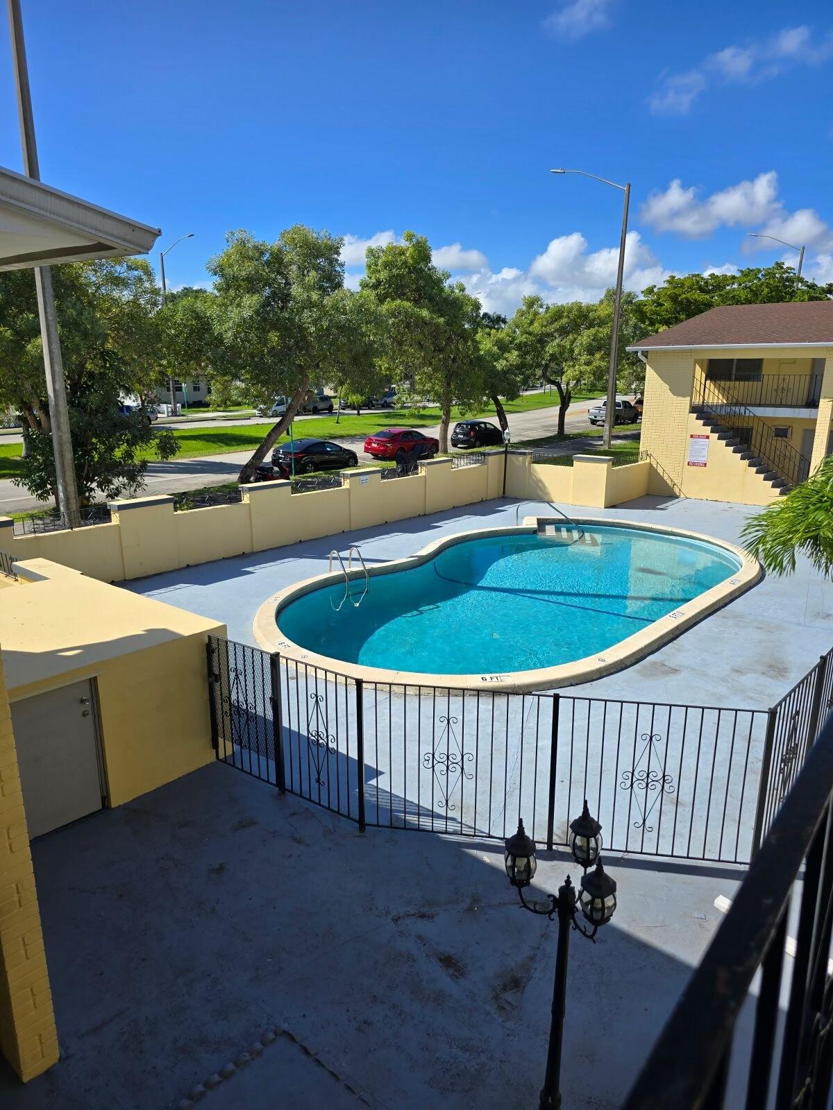 a view of a swimming pool with a patio and fire pit