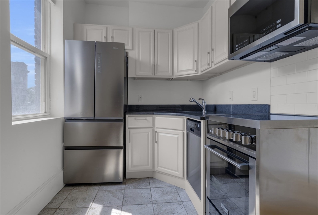 a kitchen with stainless steel appliances a refrigerator and a stove top oven