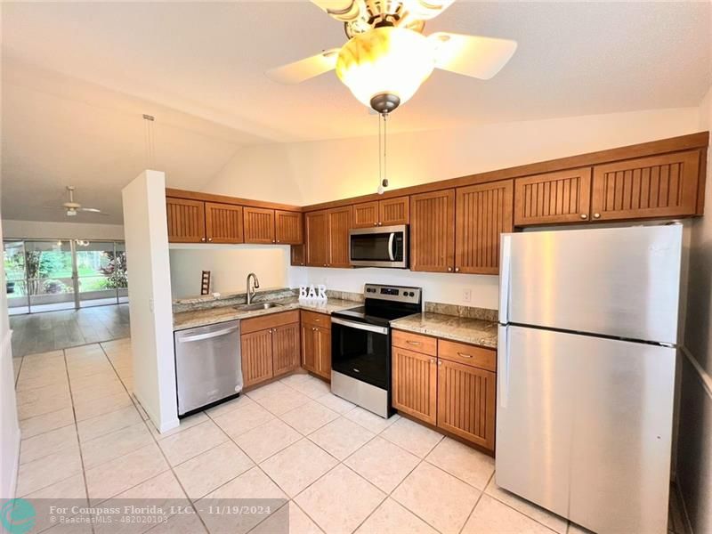 a kitchen with stainless steel appliances granite countertop a refrigerator and a stove top oven