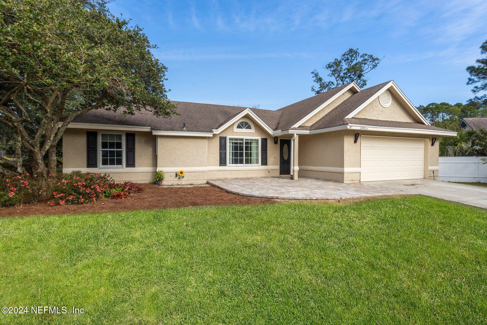 a front view of a house with yard and green space