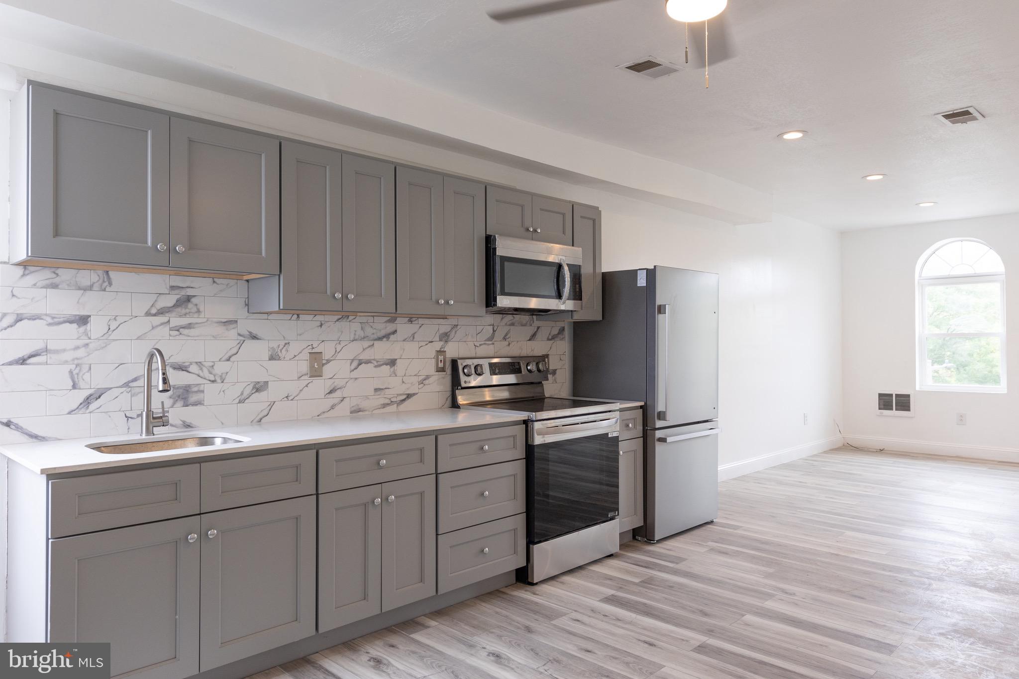 a kitchen with stainless steel appliances granite countertop a stove a sink and a refrigerator