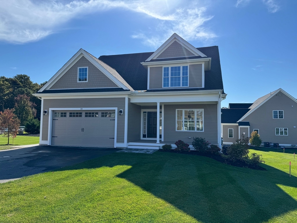 a front view of a house with a yard and trees