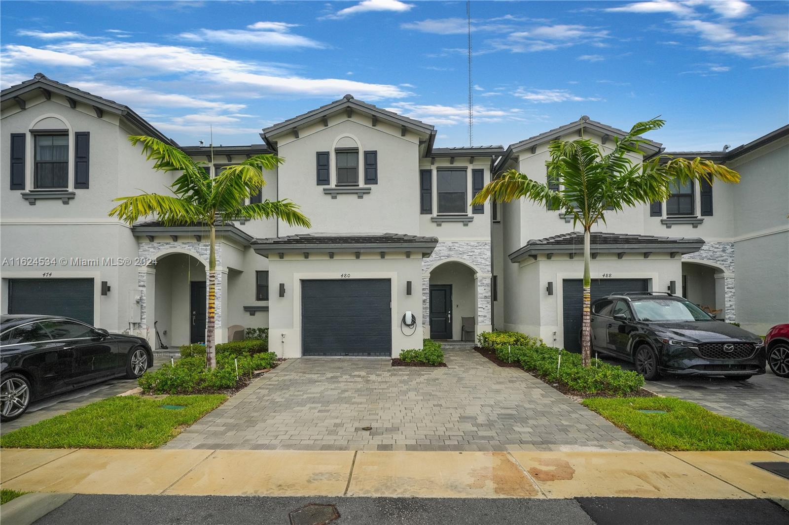 a front view of a house with a garden and garage