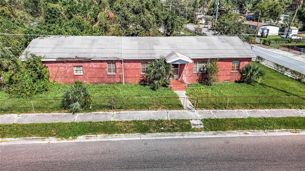 an aerial view of a house with a yard and a large tree