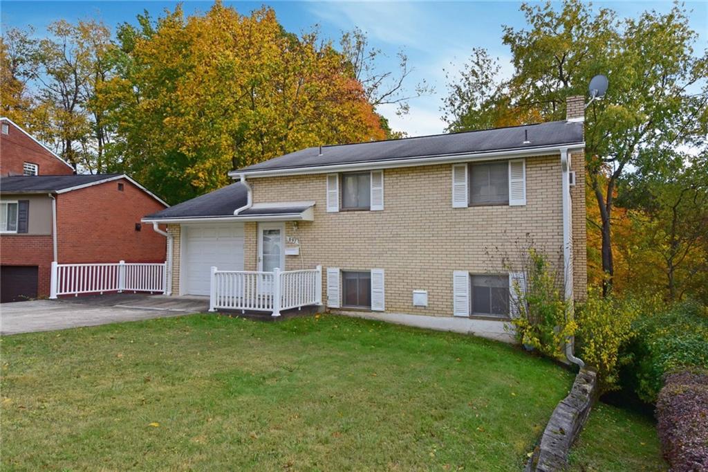 a brick house with a large tree in front of it