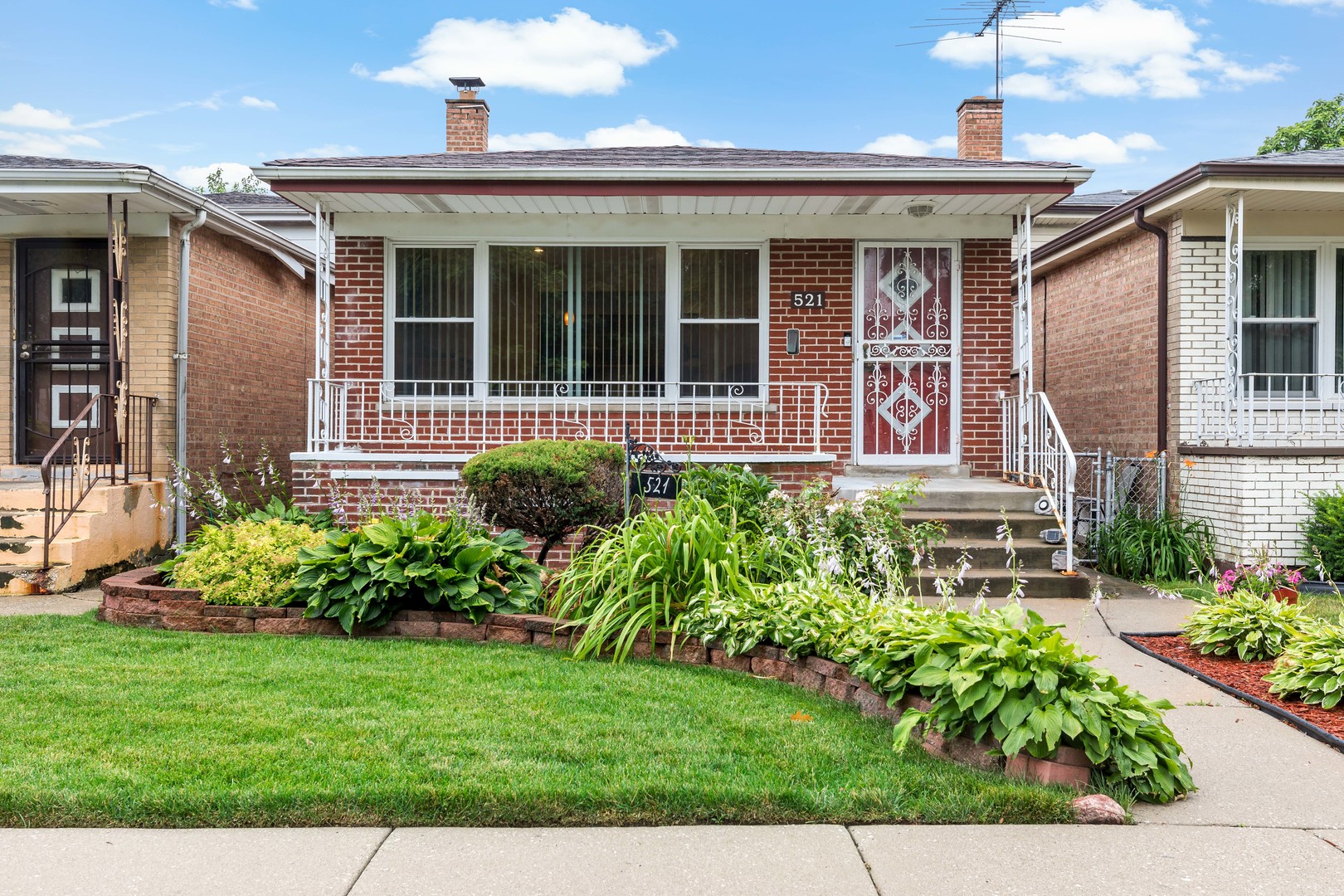 a front view of a house with a yard and potted plants