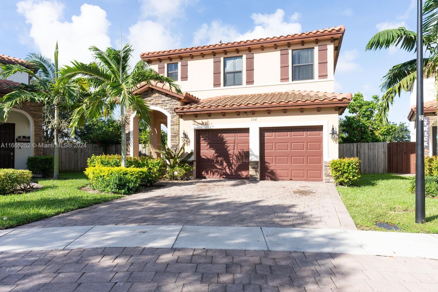 a front view of a house with a garden and plants