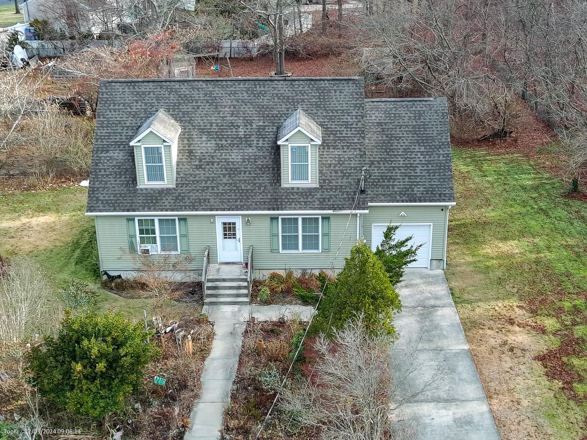 Cape cod house featuring a front yard