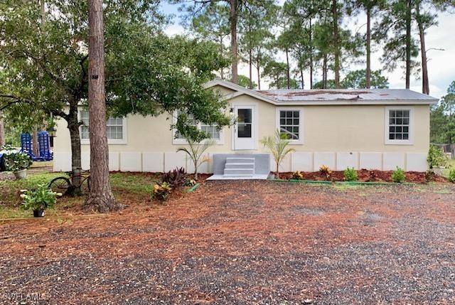 a view of a house with backyard and trees