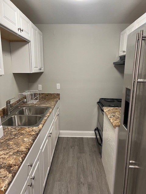 a kitchen with a sink a refrigerator and cabinets