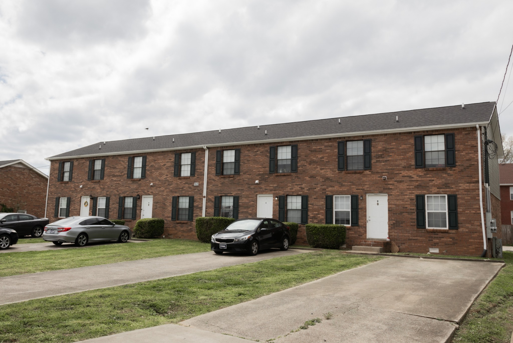 a front view of a residential apartment building with a yard