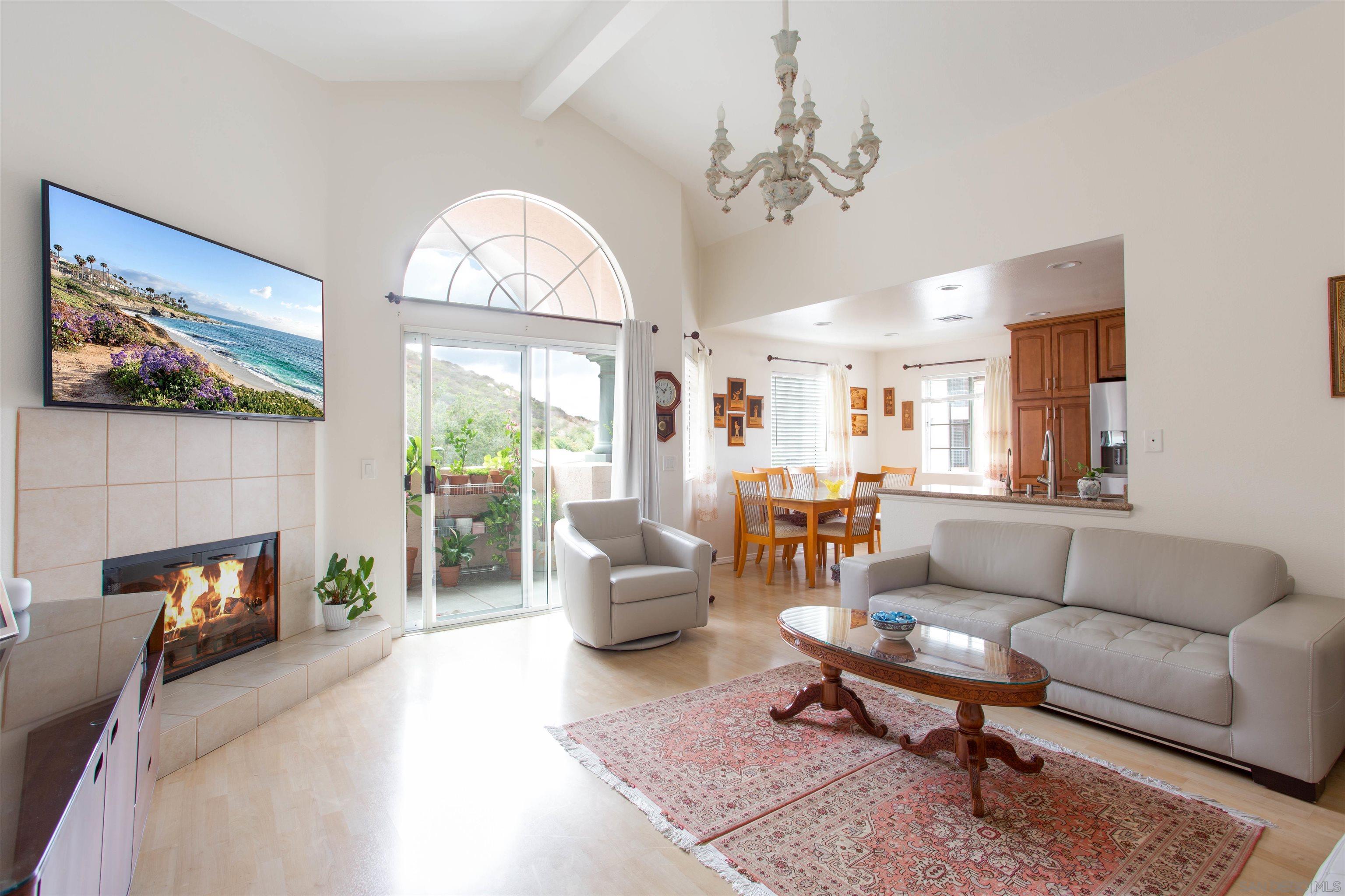 a living room with furniture a fireplace and a chandelier