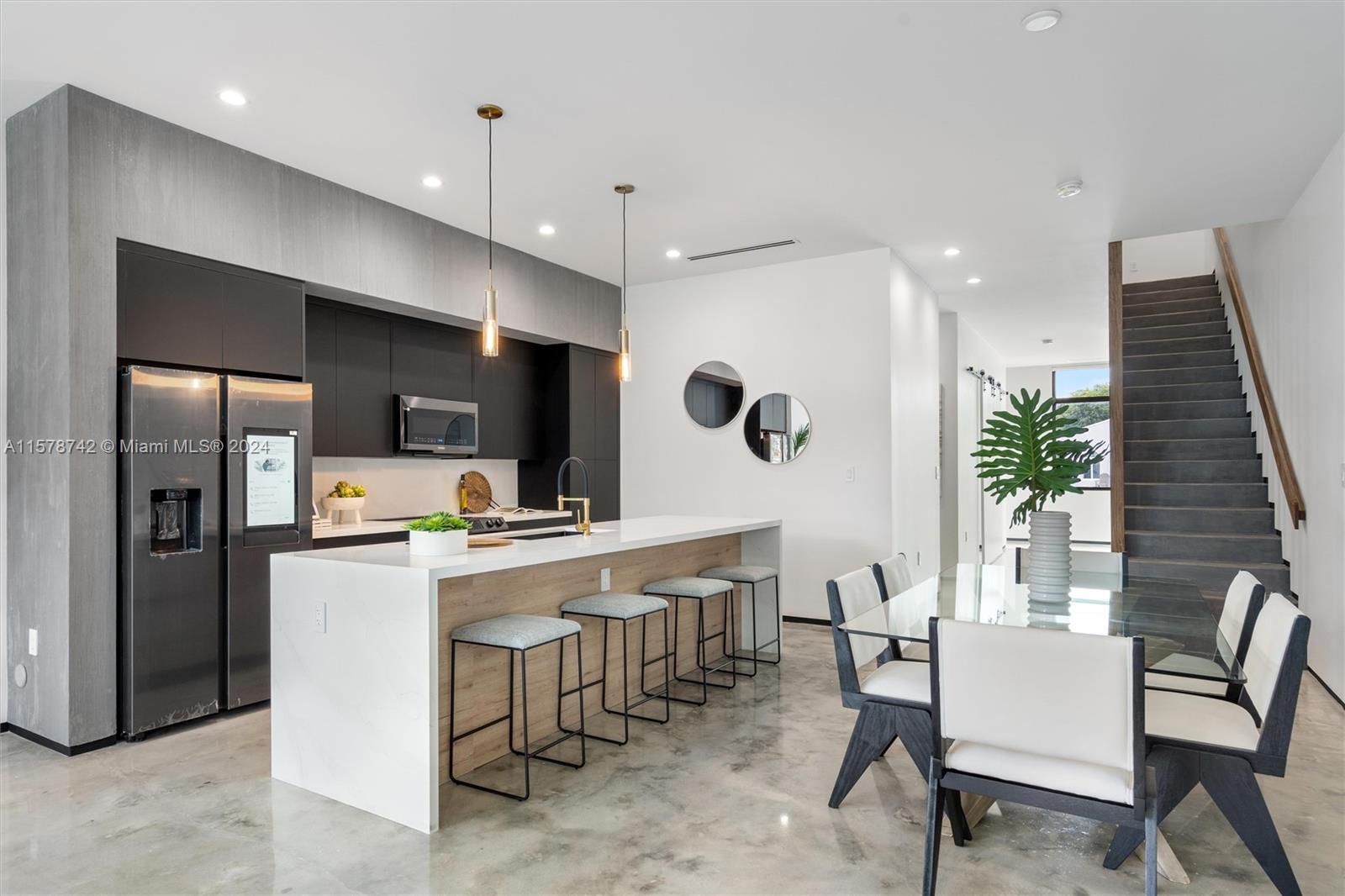 a kitchen with a table chairs refrigerator and microwave