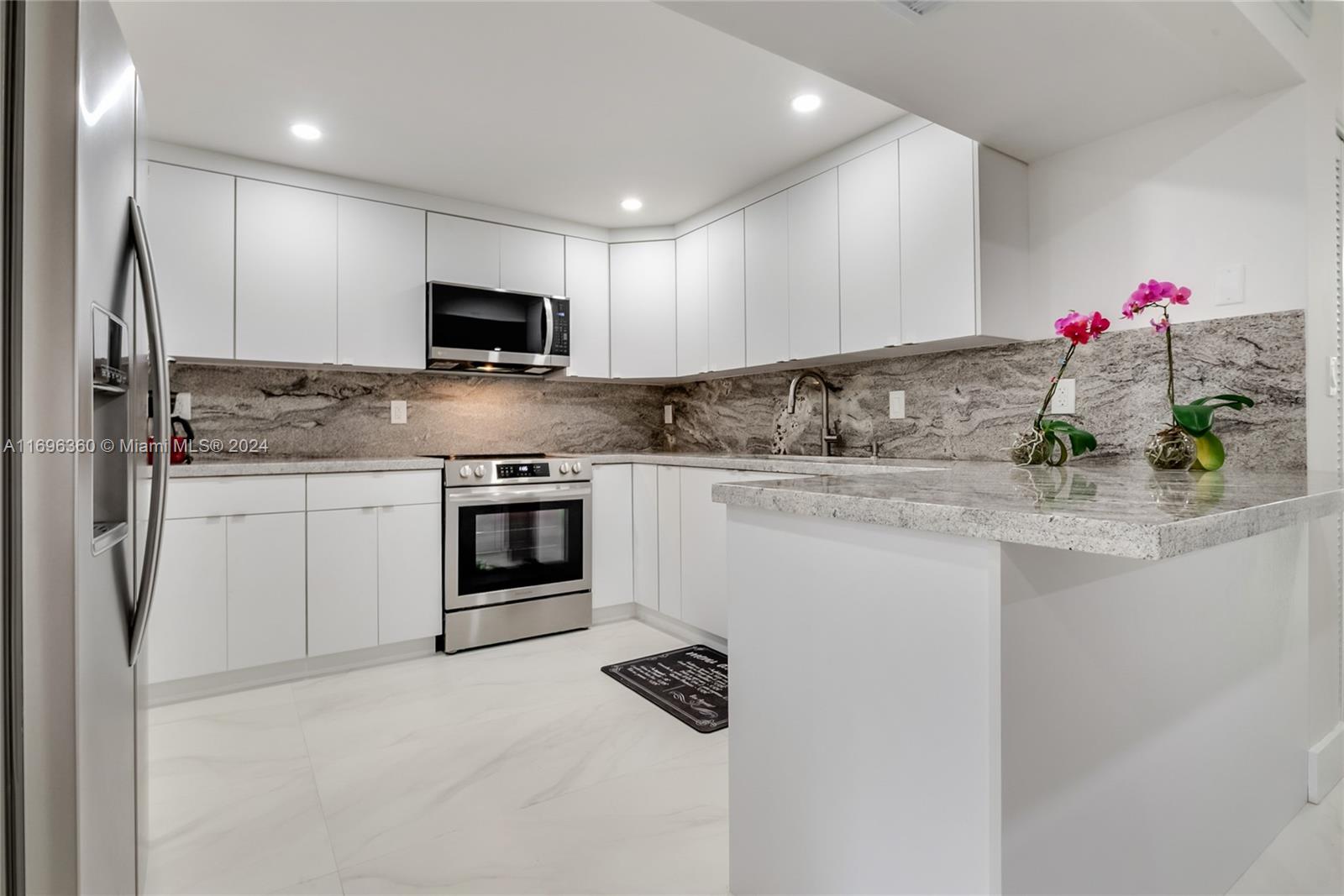 a kitchen with stainless steel appliances granite countertop a sink and cabinets