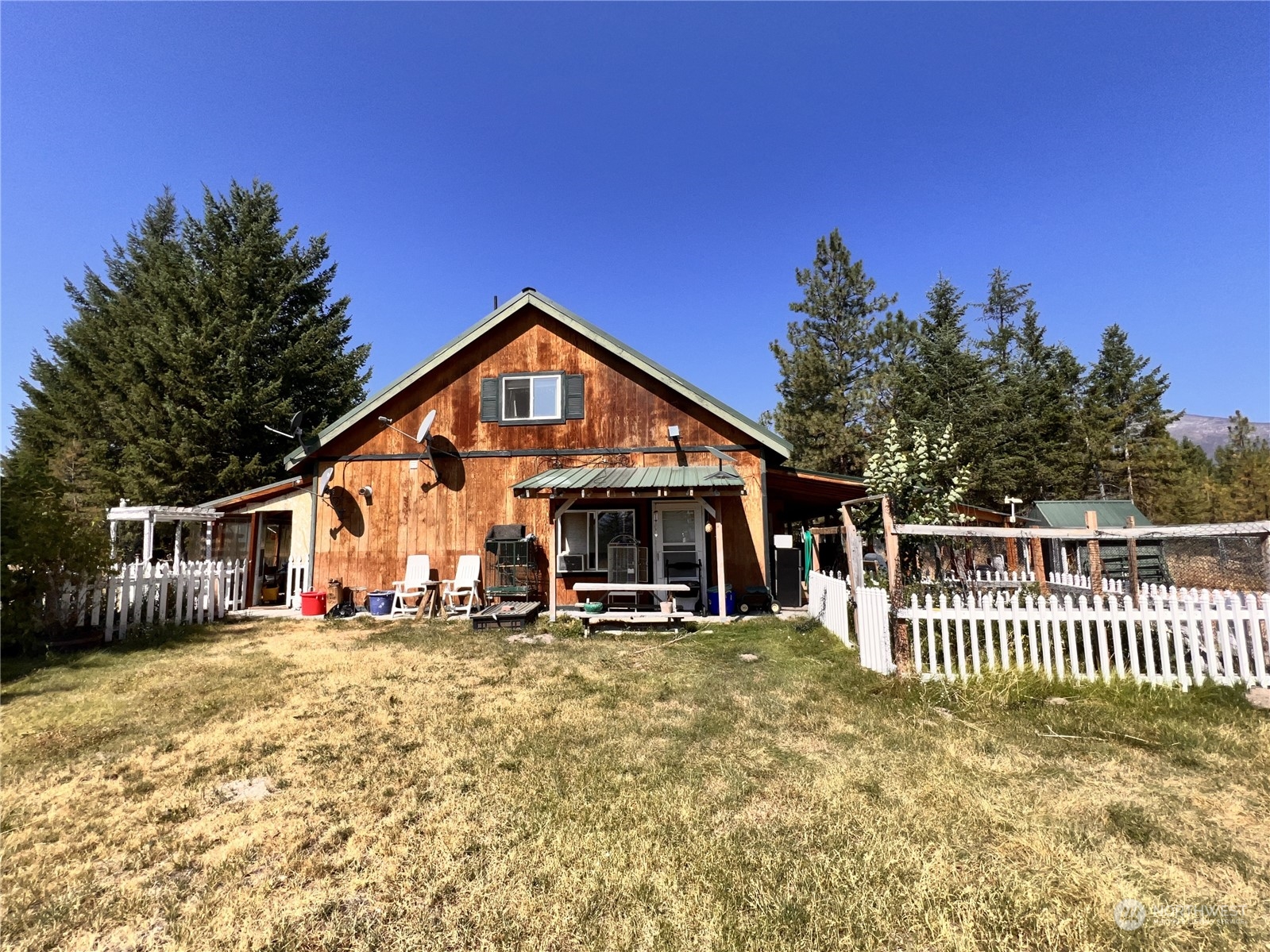 a view of a house with a yard patio and wooden fence