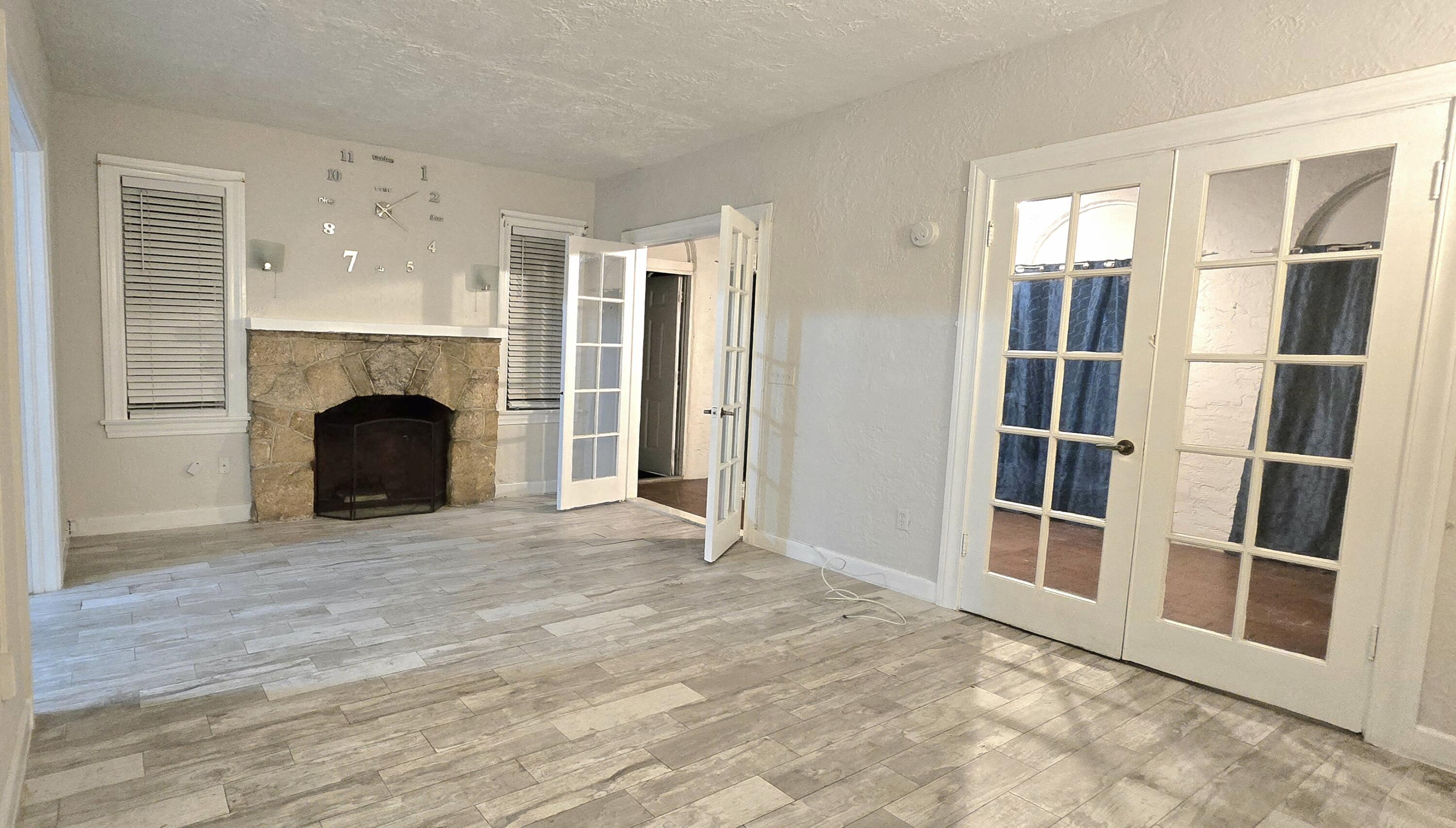 a view of an empty room with fireplace and a window