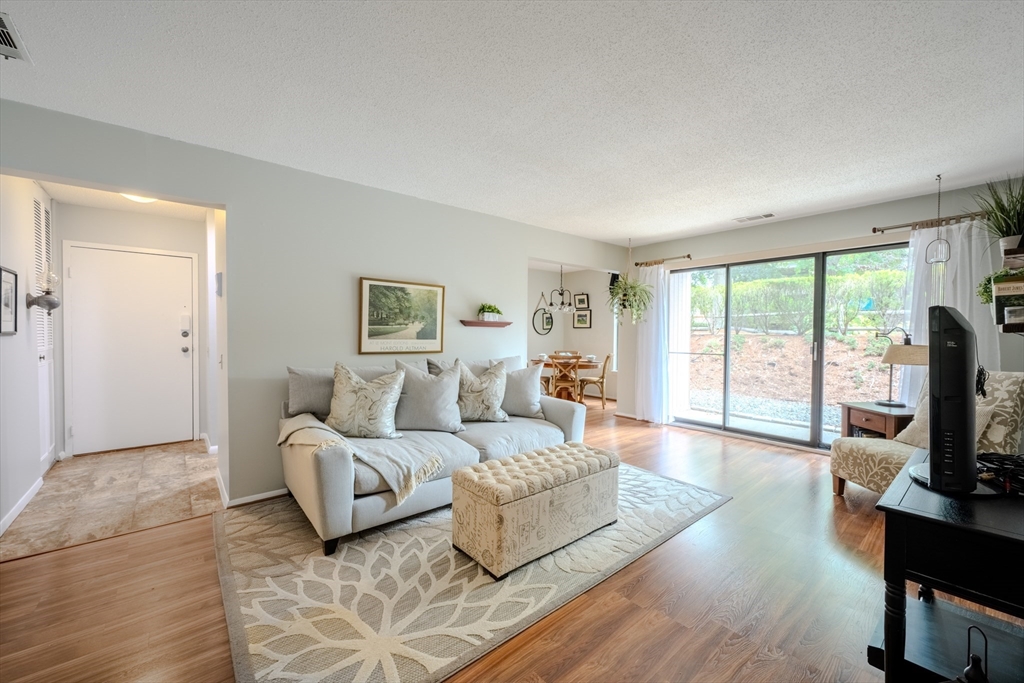 a spacious bedroom with a bed a couch and a flat tv screen on a dresser