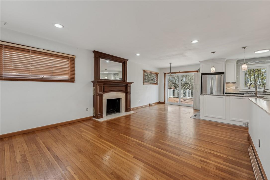 a view of empty room with wooden floor and fireplace