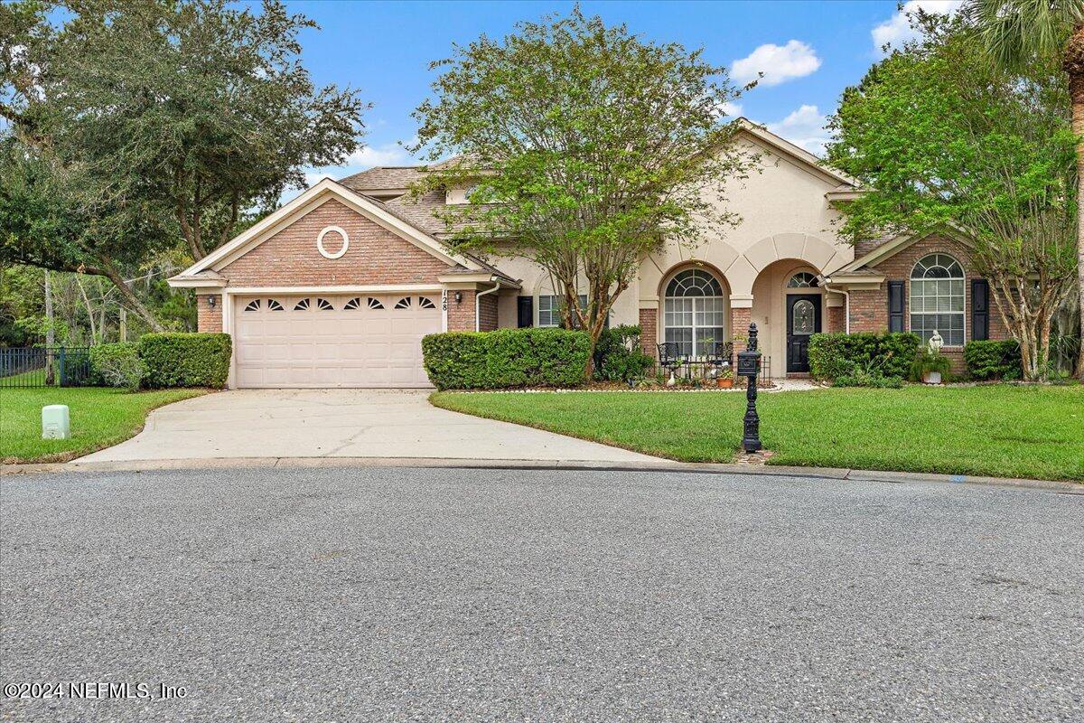 a front view of a house with a yard and garage