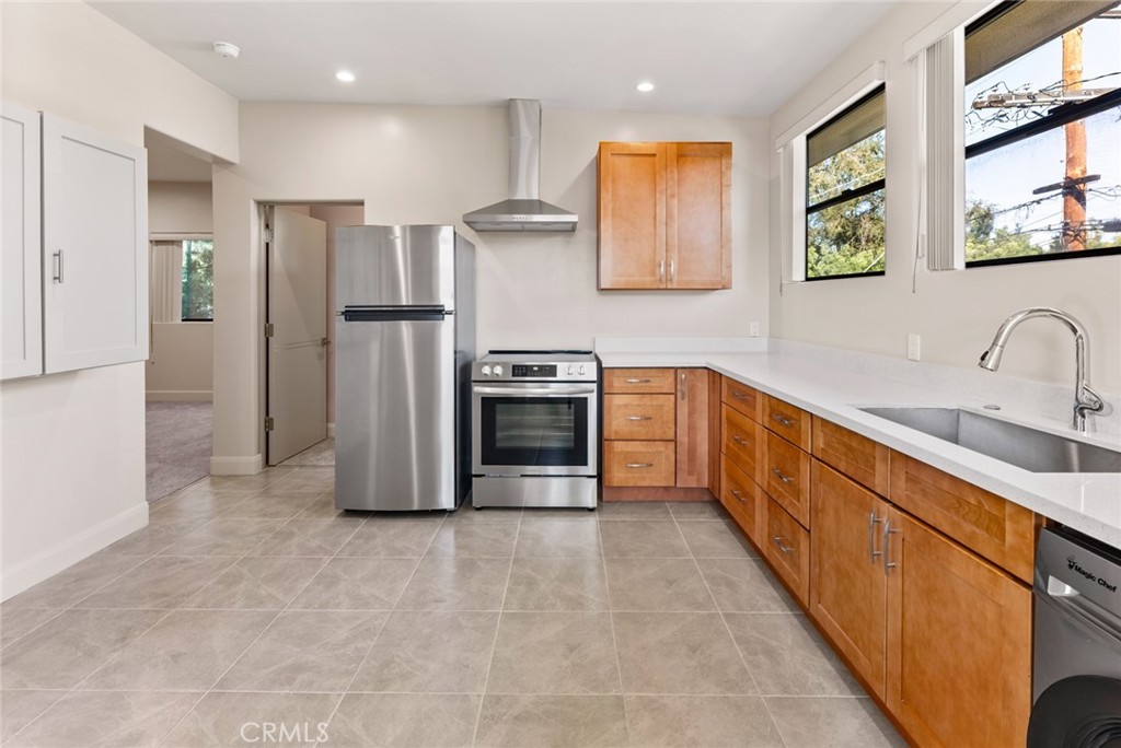 a kitchen with stainless steel appliances granite countertop a refrigerator and a sink