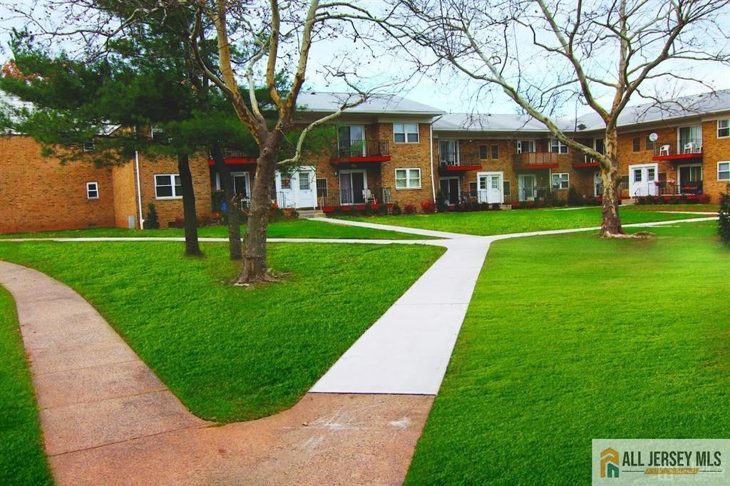 a view of a big building with a big yard and large trees