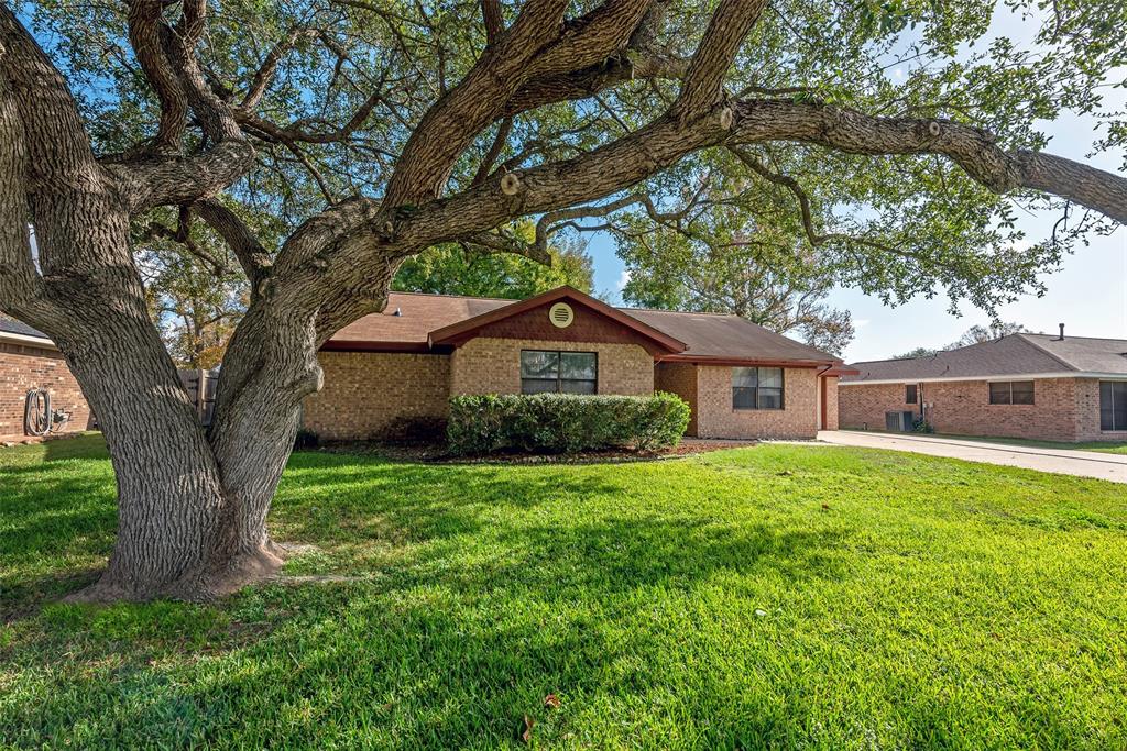 Charming brick home with a large front yard, featuring a well maintained lawn with beautiful mature oak tree offering curb appeal and shade. 