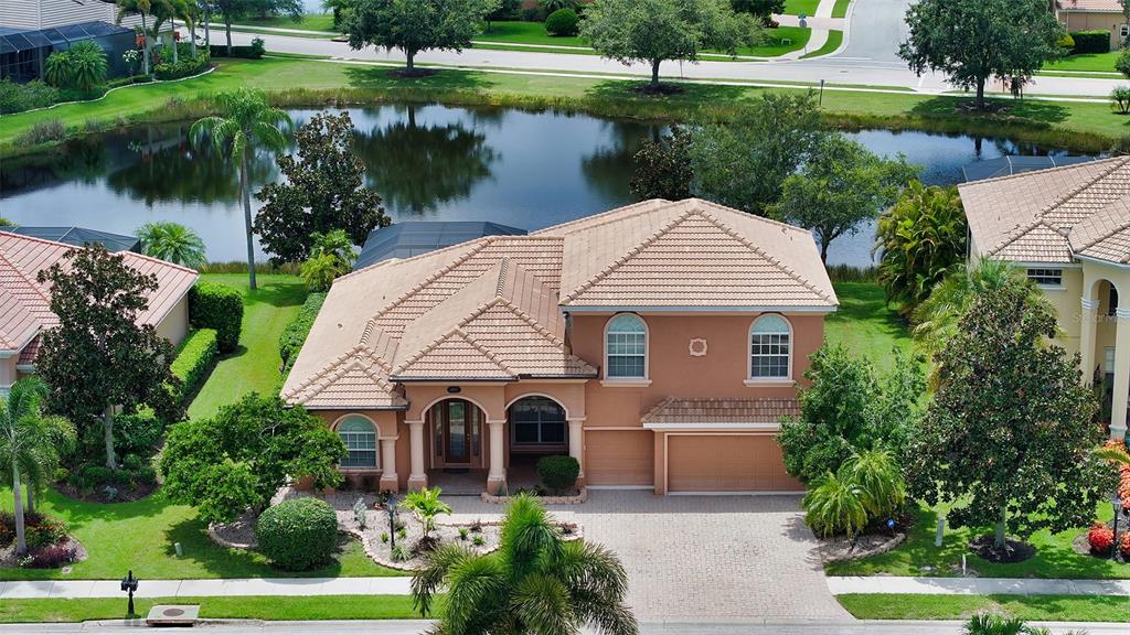 a front view of a house with a yard and lake view