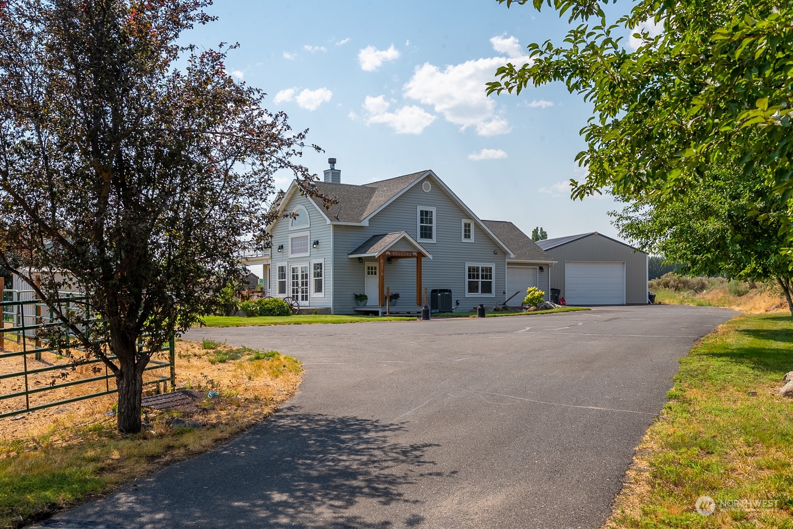 a front view of house with yard and trees in the background