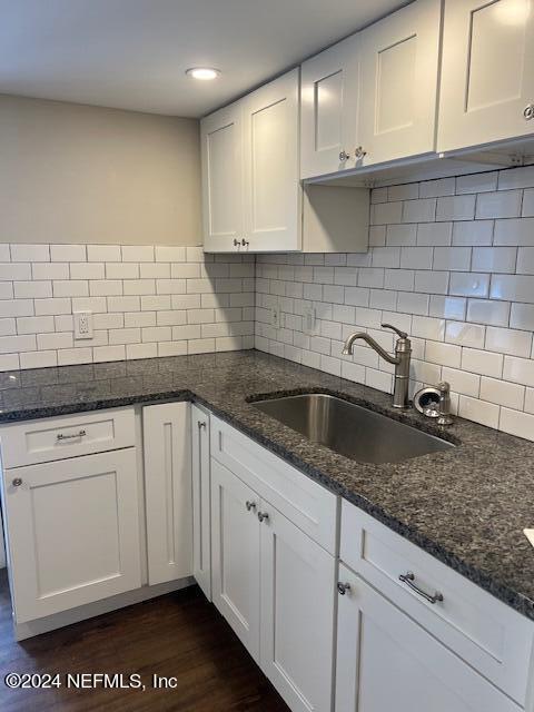 a kitchen with granite countertop white cabinets and a sink