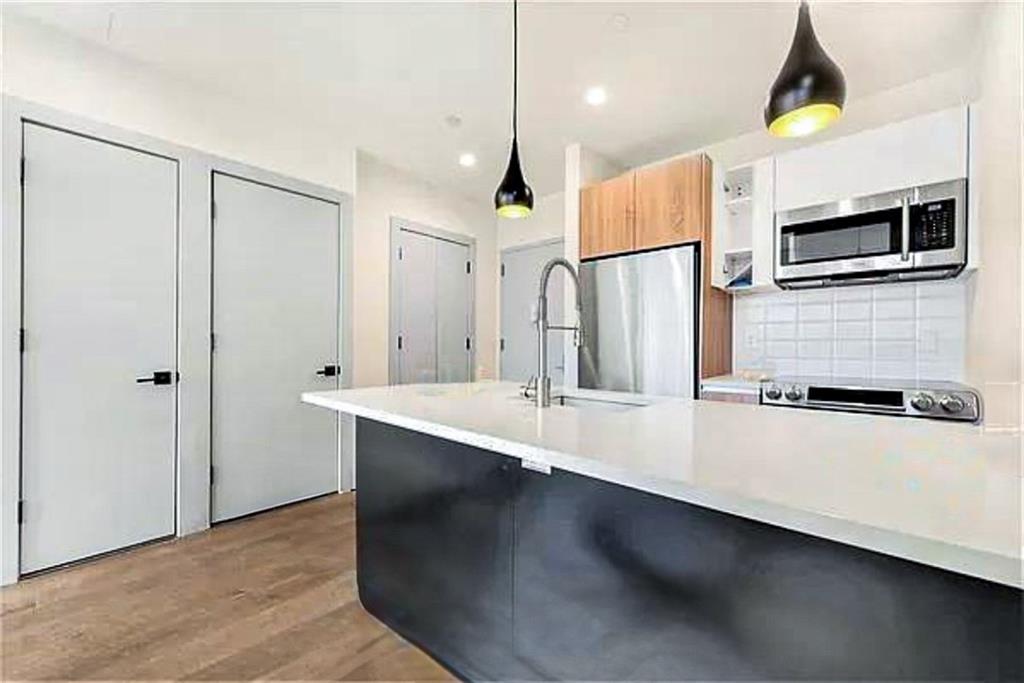 a kitchen with stainless steel appliances a microwave a sink and refrigerator