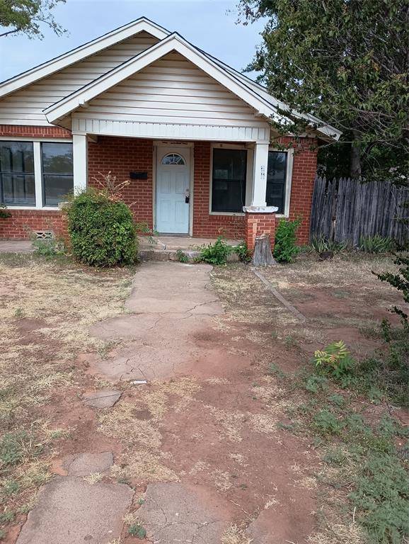 a front view of house with yard and trees around