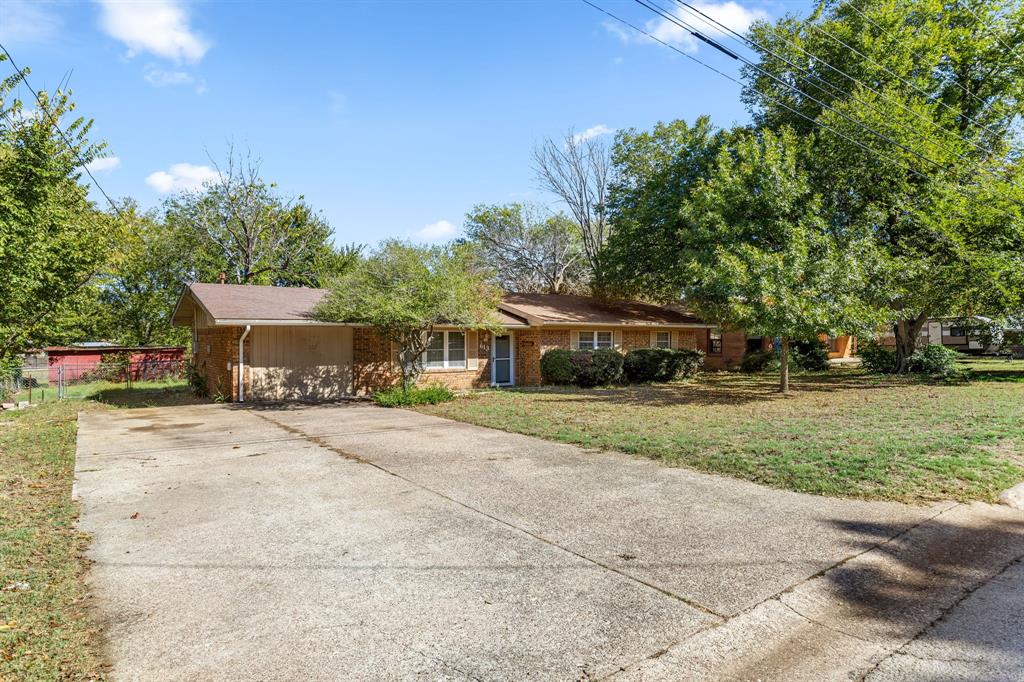 a front view of a house with a yard and trees