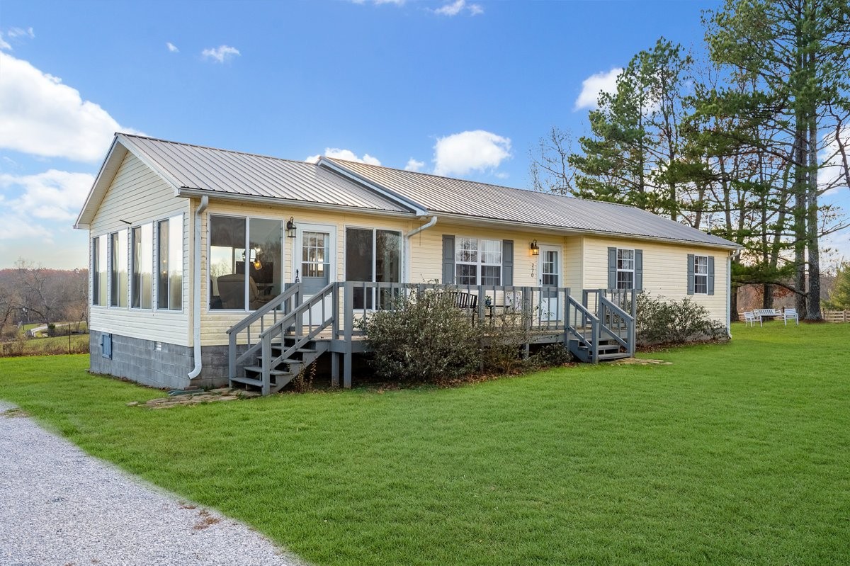 a view of a house with a yard and deck