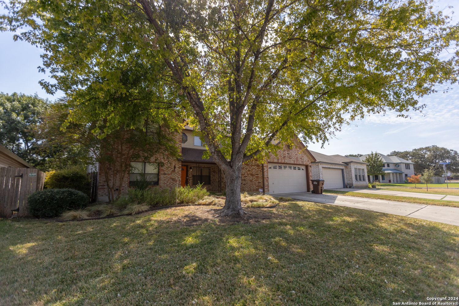 a front view of a house with a yard and trees