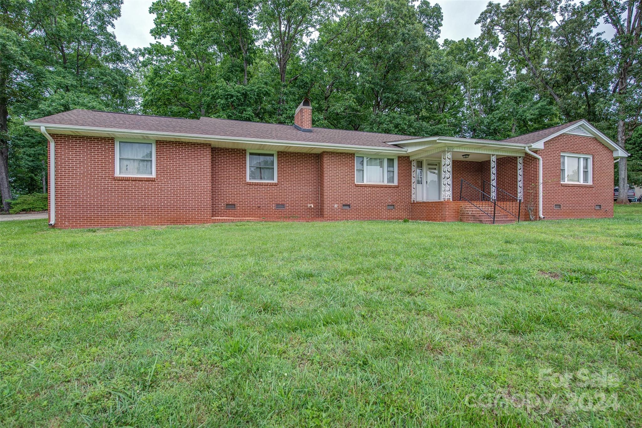 a front view of a house with yard and green space